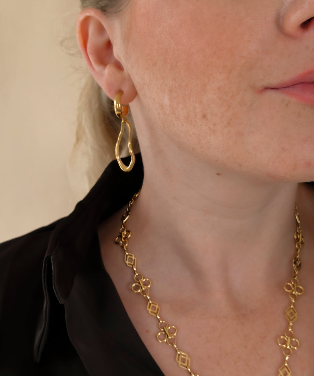 Ovelle gouden oorbellen gedragen met de Fleurette Ketting