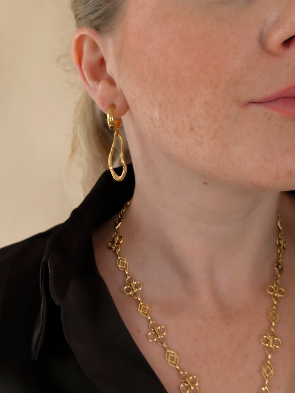 Ovelle gouden oorbellen gedragen met de Fleurette Ketting