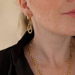 Ovelle gouden oorbellen gedragen met de Fleurette Ketting