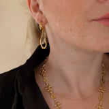 Ovelle gouden oorbellen gedragen met de Fleurette Ketting