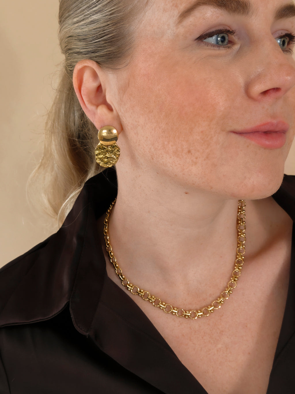 Solene gouden oorbellen gedragen met een donkere blouse en Lace ketting | gedragen