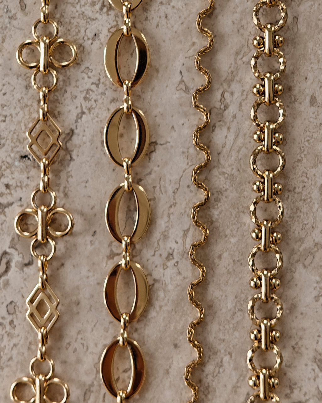 Gouden BLOSS Essentials met bloemmotieven, ovale schakels, een golvende ketting en bewerkte ronde schakels