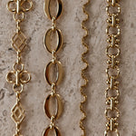 Gouden BLOSS Essentials met bloemmotieven, ovale schakels, een golvende ketting en bewerkte ronde schakels
