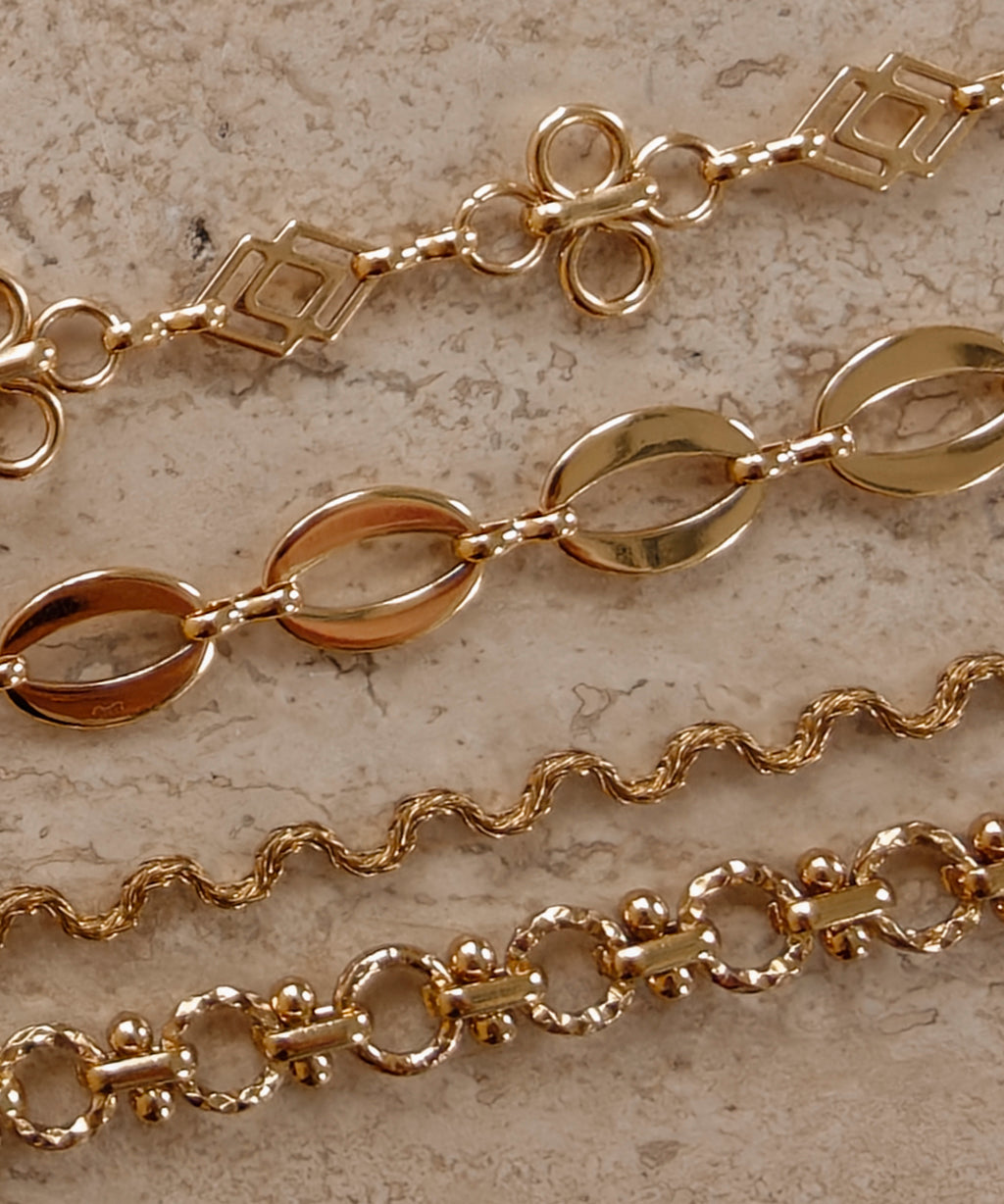 Gouden BLOSS Essentials met open bloemmotieven, ovale schakels en golvende schakels