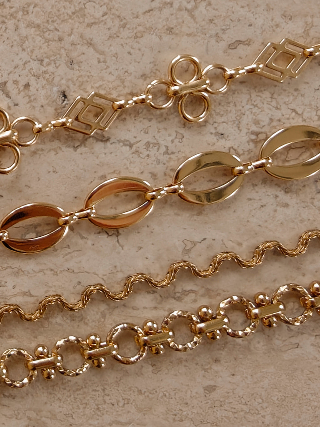 Gouden BLOSS Essentials met open bloemmotieven, ovale schakels en golvende schakels