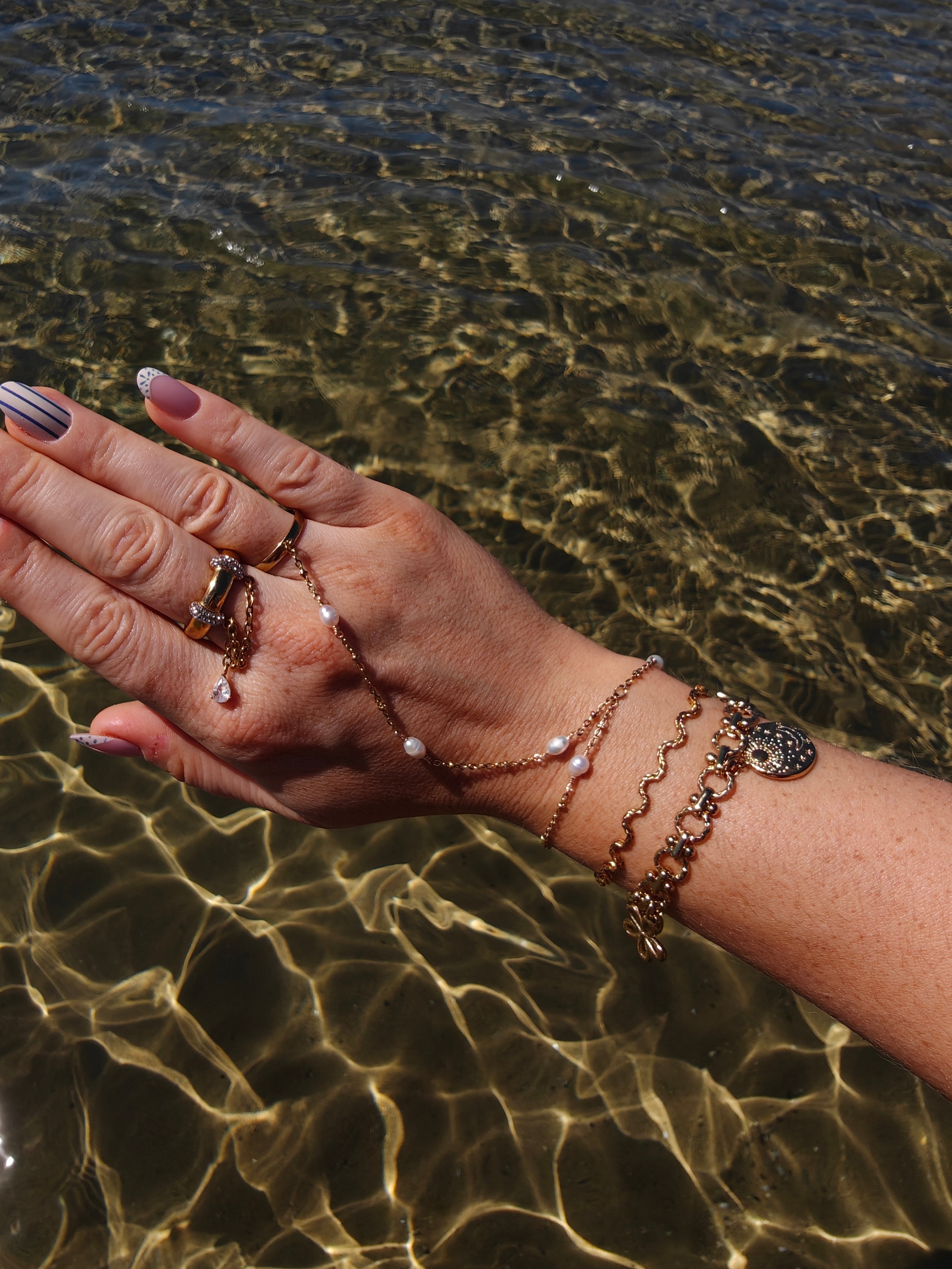 Coquette gouden armband met bloemen, een hart en medaillons | gedragen