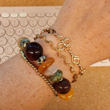 Gouden BLOSS armbanden gecombineerd met een edelstenenarmband